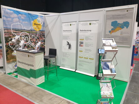 Bild des Messestandes der Radonbaratung mit Faltaufstellern und einem Beratungstresen